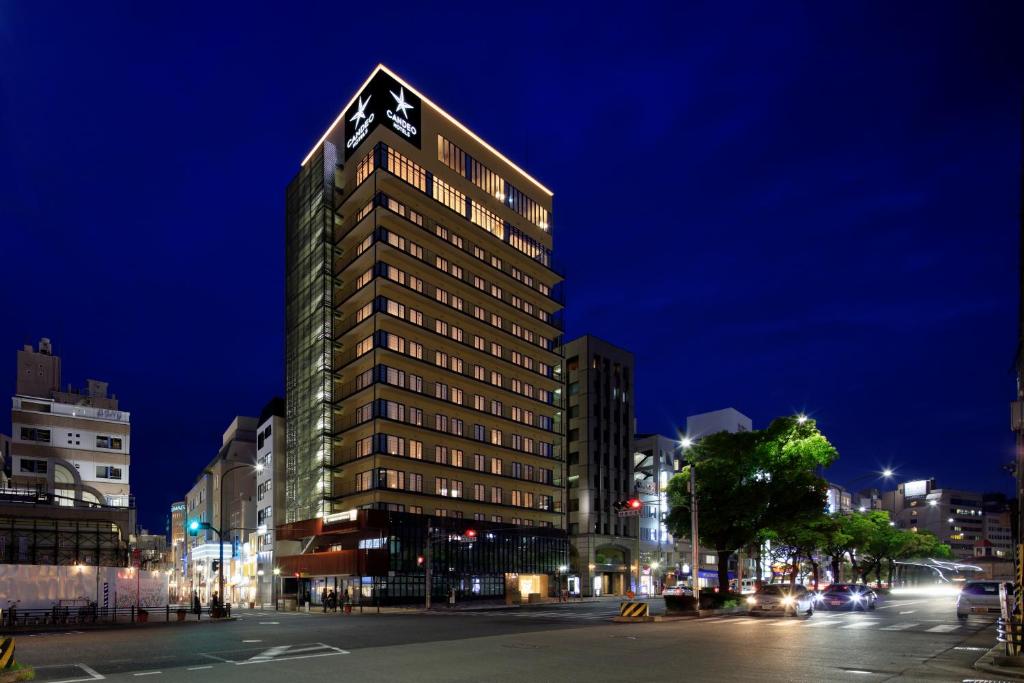 a tall building with a clock on the top of it at Candeo Hotels Kobe Tor Road in Kobe