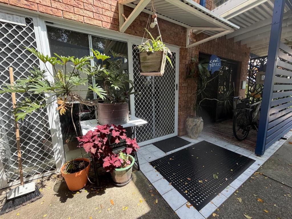 a porch with potted plants on the side of a house at Cod Place in Beautiful South West Rocks in South West Rocks