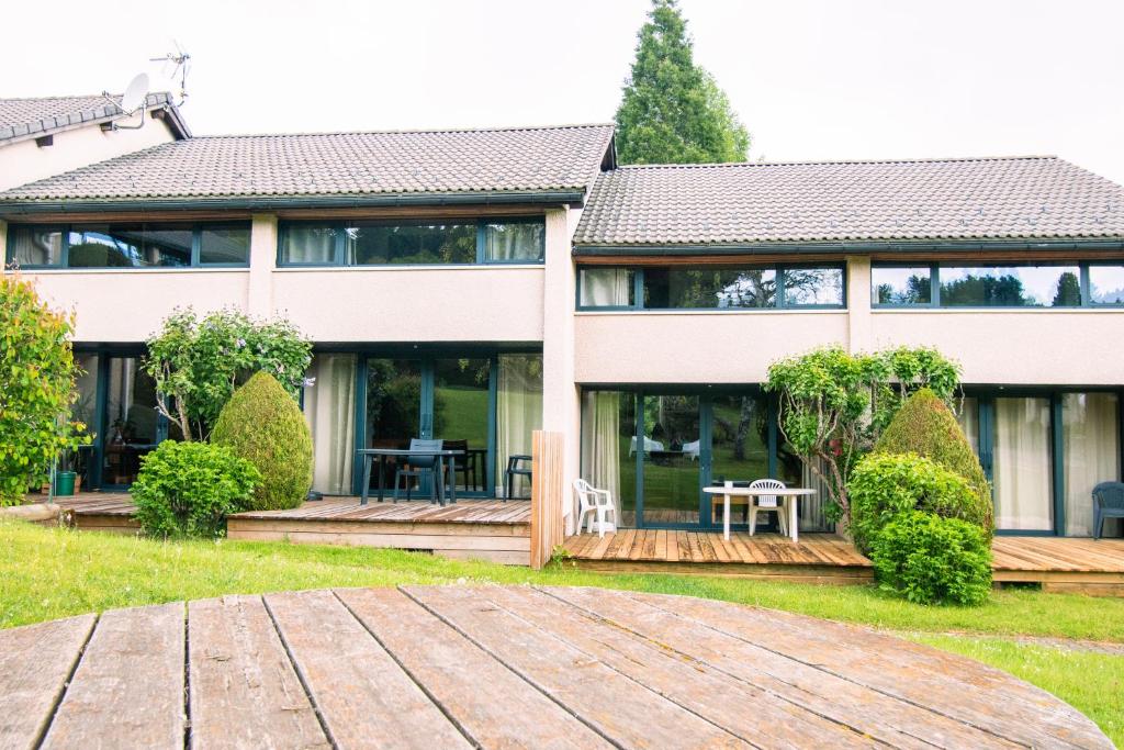 a house with a wooden deck in front of it at Val Du Rio in Le Chambon-sur-Lignon