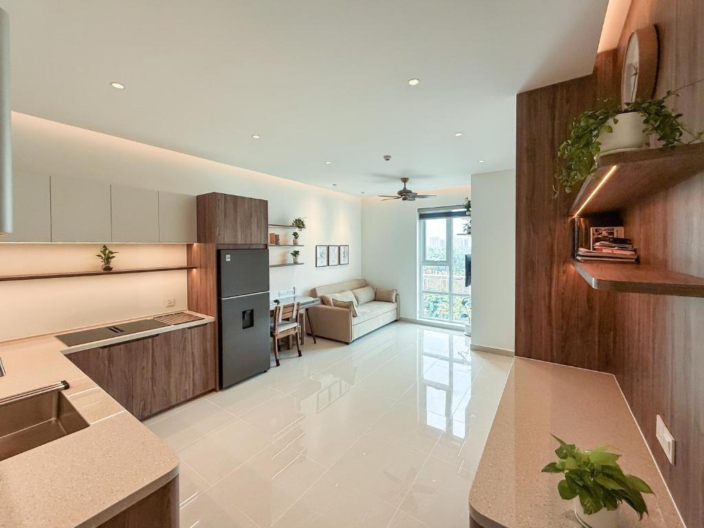 a kitchen with white walls and wooden cabinets at Hygge Haven Saigon in Ho Chi Minh City