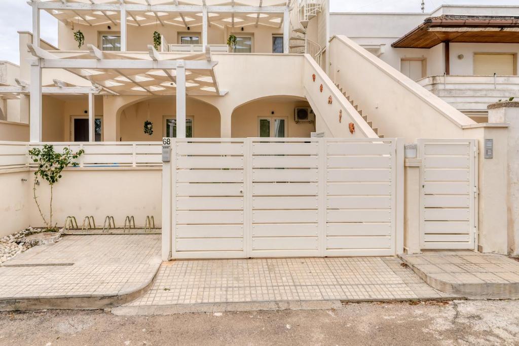 een witte poort voor een huis bij Appartamento Corallo in Porto Cesareo