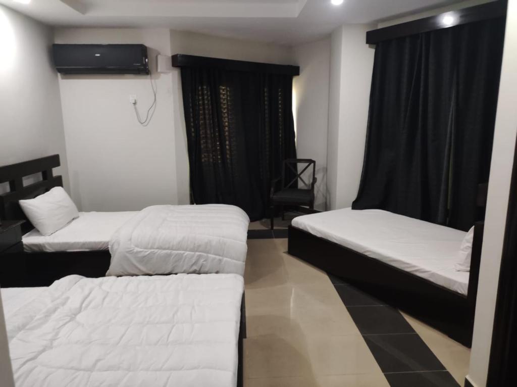 a room with two beds and a window at Moon Living Apartment Peshawar in Peshawar