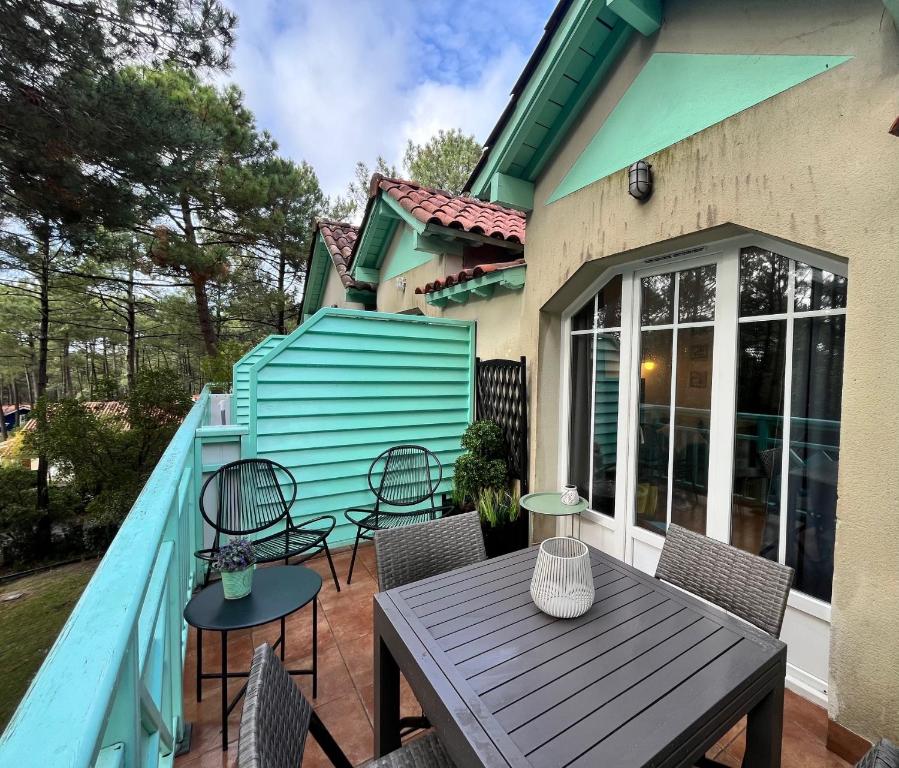 a deck with a wooden table and chairs on a house at La Perle des Pins LACANAU OCEAN in Lacanau