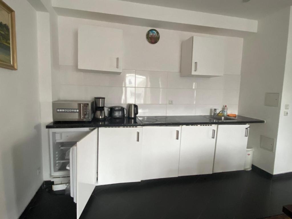 a kitchen with white cabinets and a black counter top at The Greenstead in Hannover