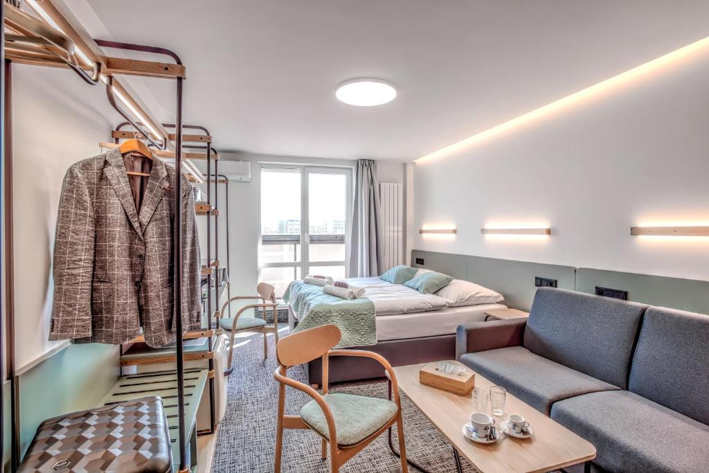 a living room with a couch and a bed at STEELHOUSE Hotel in Třinec