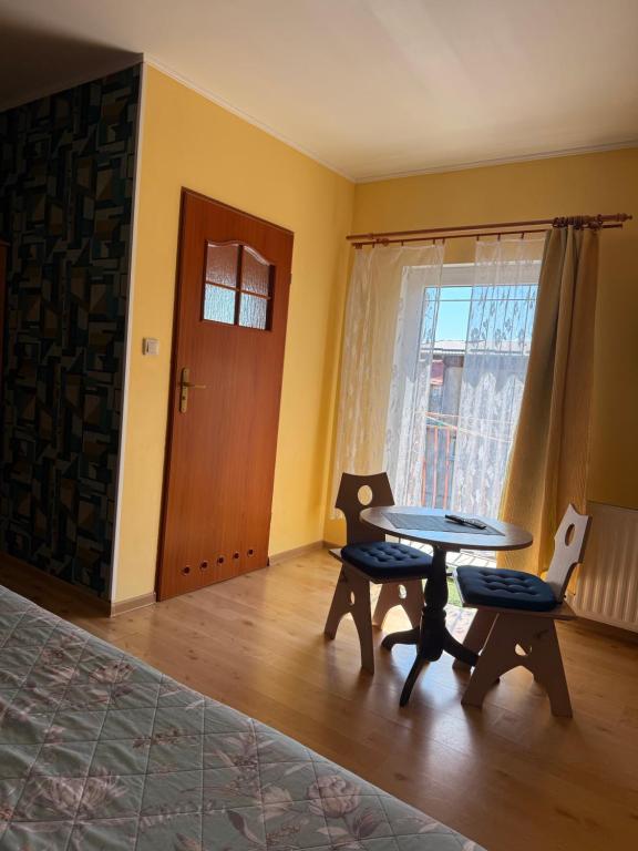 a room with a table and two chairs and a door at Dom wczasowy Max in Darłowo
