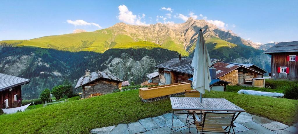 a patio with an umbrella in front of a mountain at Ferienwohnung CAMANABODA in Camanaboda