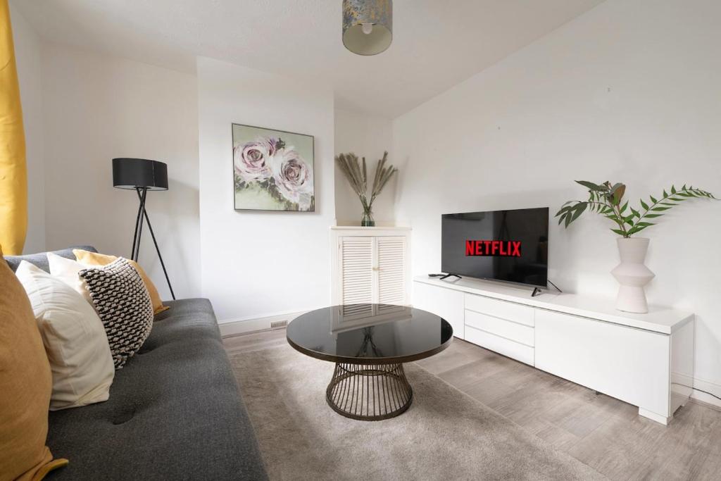 een woonkamer met een bank en een tv bij Chill in Gill Comfy House, Free Parking x 1 in Gillingham