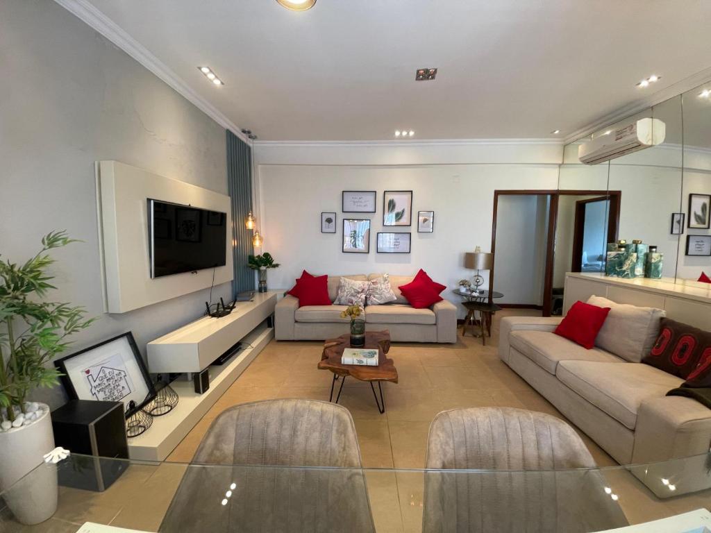 a living room with a couch and a tv at The Fifth in Luanda