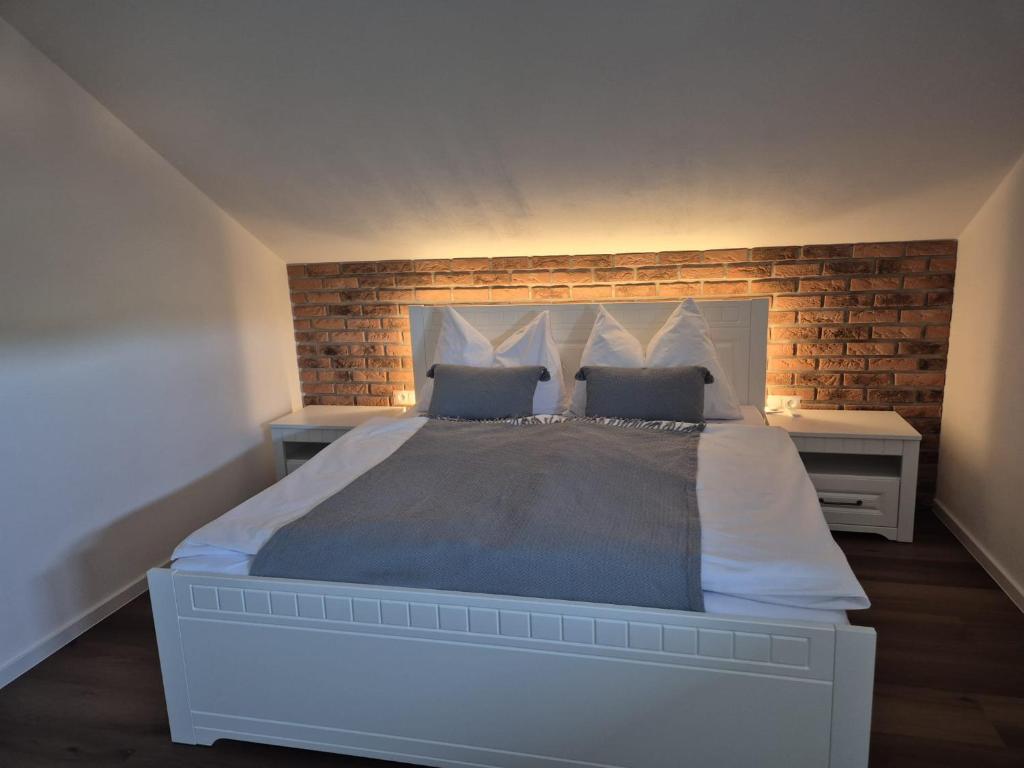 une chambre avec un grand lit avec un mur de briques dans l'établissement Apartmán By One, à Banská Štiavnica
