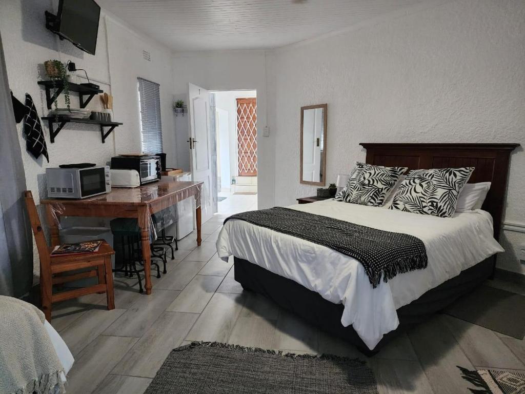 a bedroom with a bed and a desk and a computer at Groenewald's Haven in Nelspruit