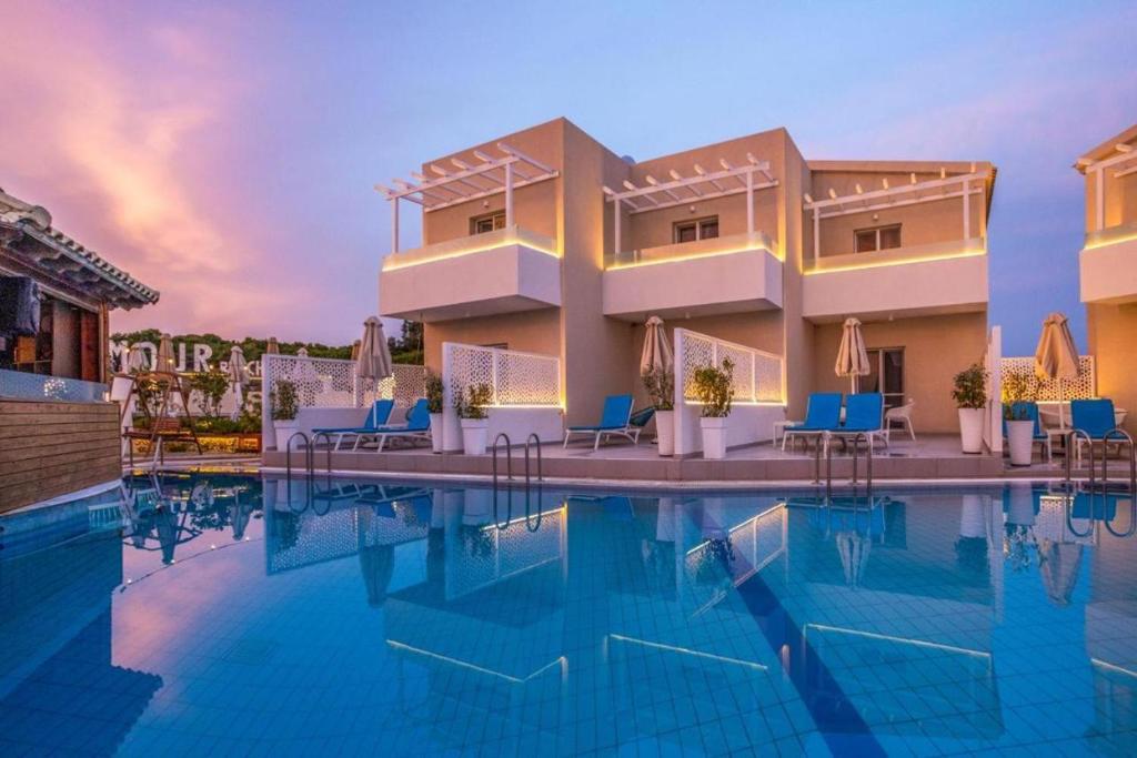 a view of a resort pool with blue chairs at Exclusive Del Mare Hotel in Sidari