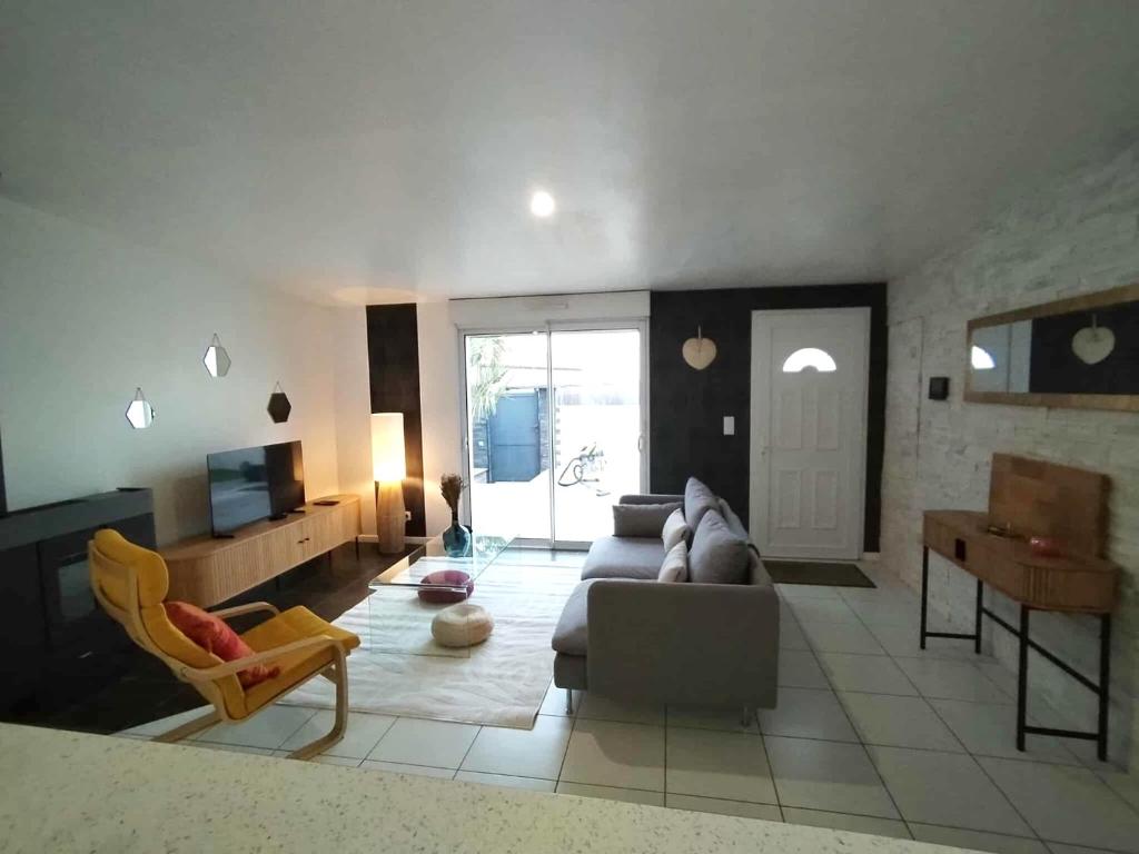 a living room with a couch and a table at Villa détente - Entre terre et mer in Le Gué-dʼAlléré
