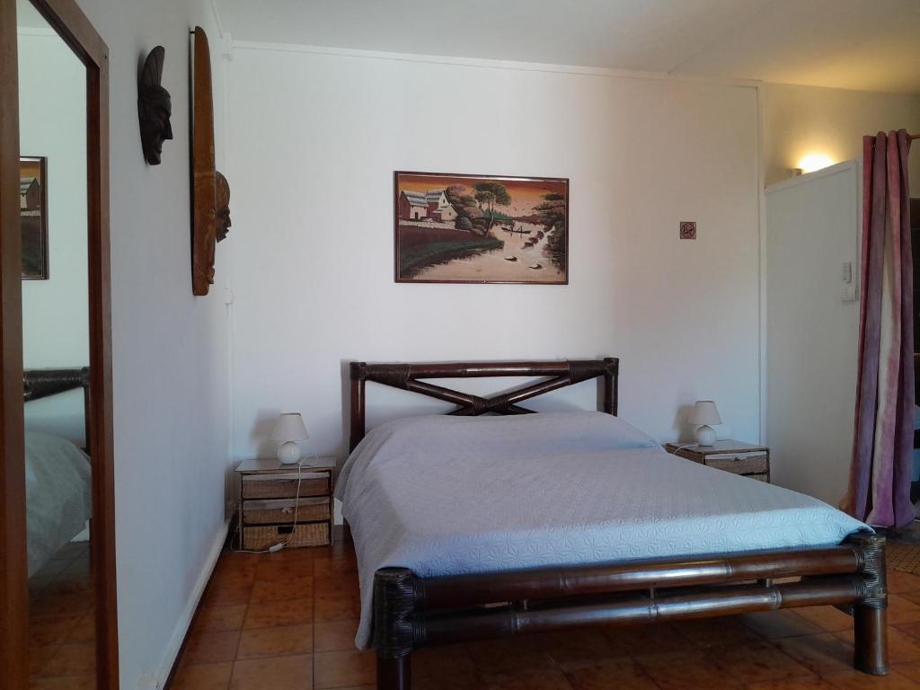 a bedroom with a bed and a picture on the wall at Le Tuléar - Aux 4 coins du monde in Saint-Pierre