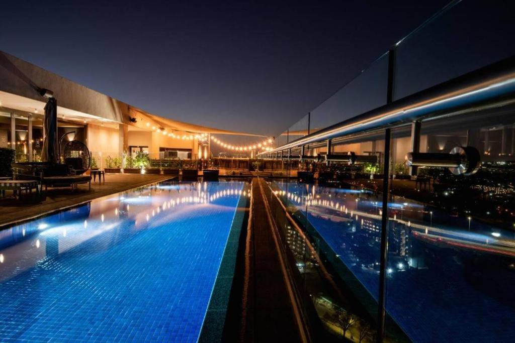 a large swimming pool in a building at night at The Capital Trilogy Hotel in Pretoria