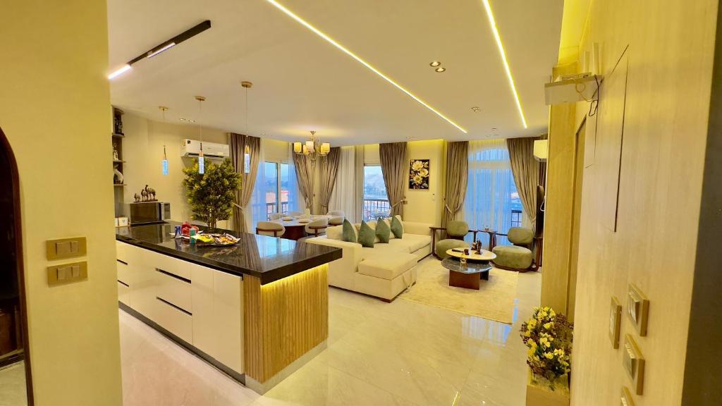 a large kitchen and living room with a couch and a table at Ultra Luxury 3BR with Pools ,Sports ,Dining in Gated compound, Close to all sites in Cairo