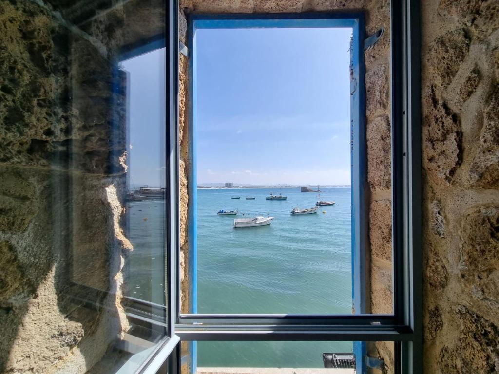 a window view of the ocean with boats in the water at Loft in the wall in ‘Akko