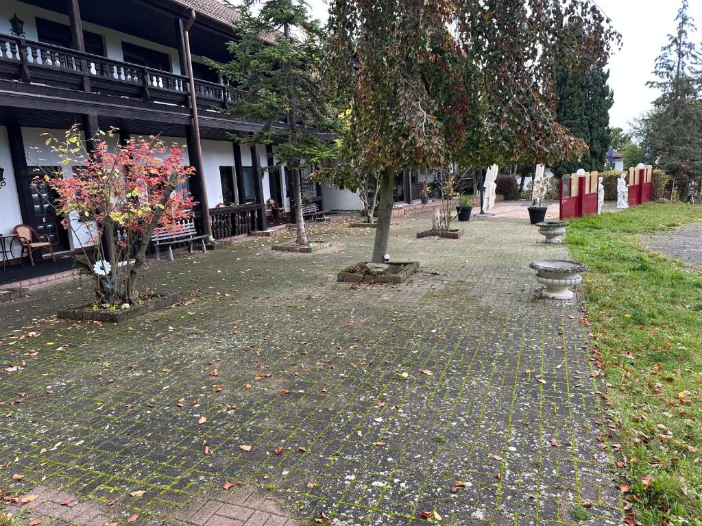 a park with benches and trees in front of a building at Motel Zur Festwiese in Gierstädt