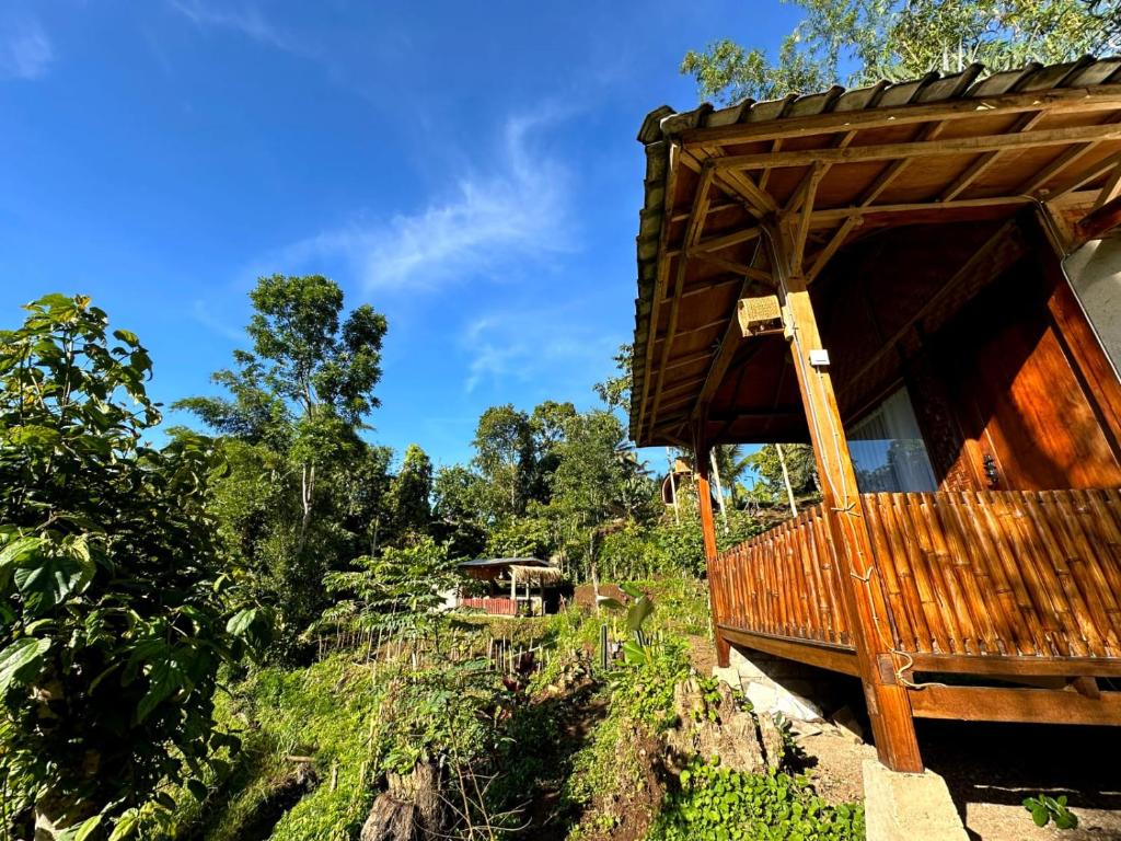 a wooden building on a hill with trees in the background at Bareng Homestay Tetebatu in Tetebatu