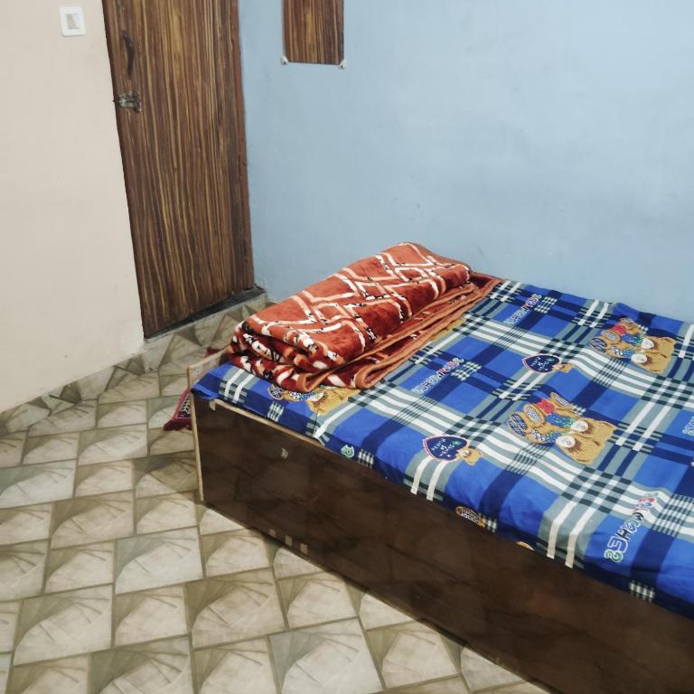 マトゥラーにあるGaurangi Mathura dharamshalaの青と白の部屋に置かれたベッド