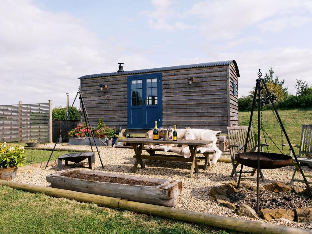 a tiny house in a yard with a picnic table at Lillie's Shepherds Hut at Shepherds Lodge Retreat and Wellness in Nottingham