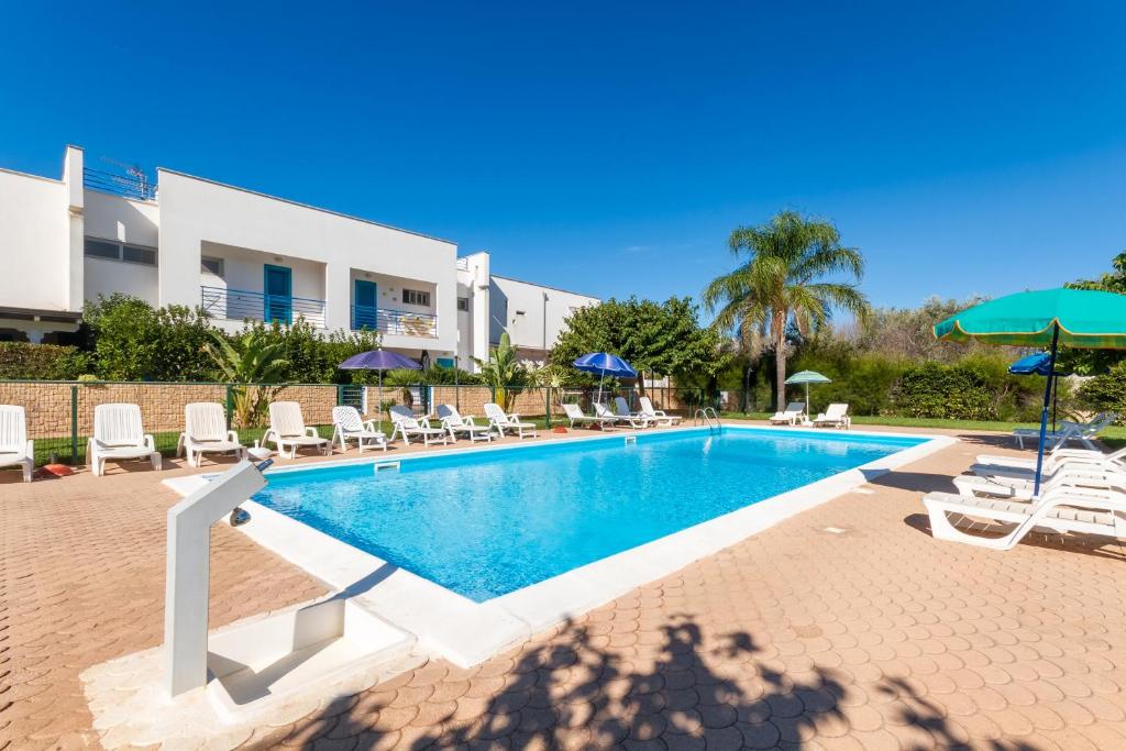 a swimming pool with lounge chairs and umbrellas at Dimora Riva Serena con Piscina in Torre Lapillo