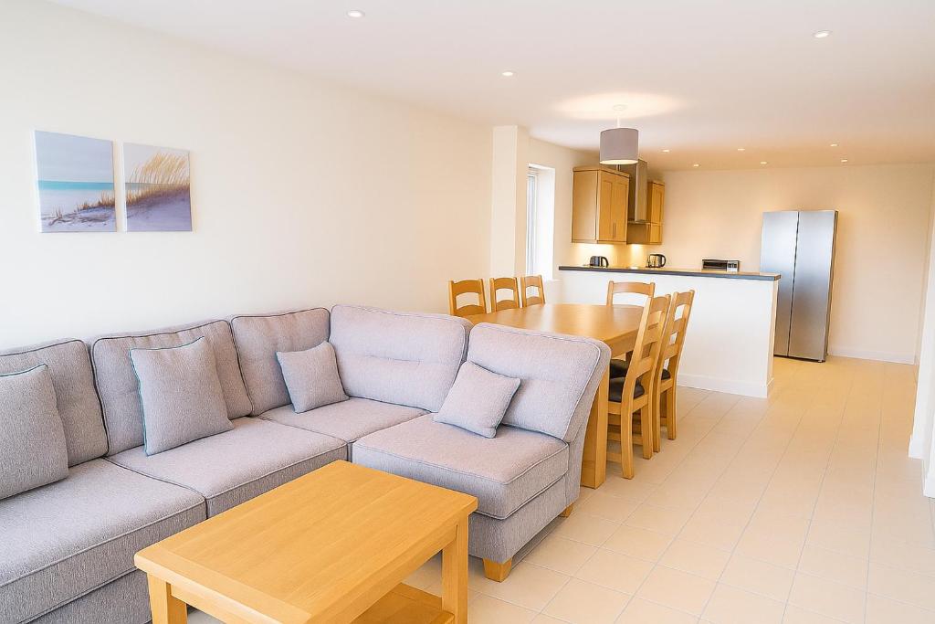 una sala de estar con un sofá y una mesa en West Beach - Holiday Apartments, en Westward Ho