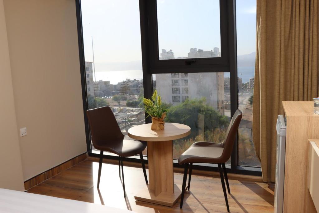 a table and chairs in a room with a large window at Ailana Hotel in Aqaba