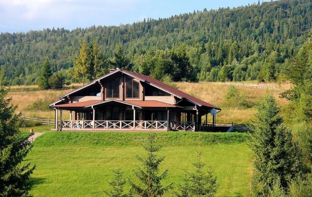 a large house on a hill in a field at Шале Задільське in Dolzhki