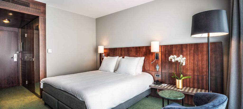 a hotel room with a bed and a table and a chair at NH Brussels EU Berlaymont in Brussels