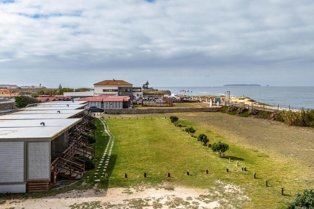an aerial view of a row of buildings and the ocean at PenichePraia - Bungalows, Campers & SPA in Peniche