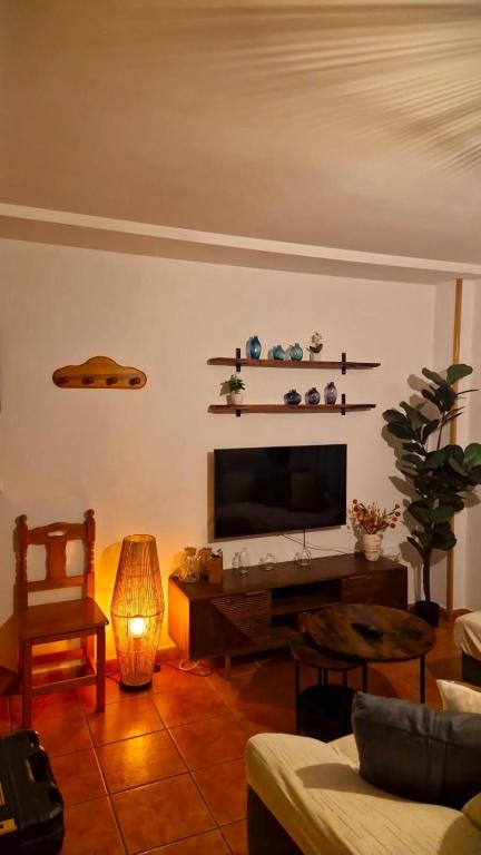a living room with a television and a couch and a table at La Casa del Senderista in Arroyo Frio