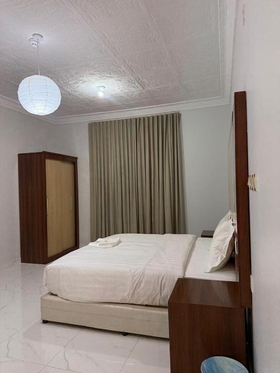 a bedroom with a white bed and a window at ريحانة الورود للشقق المخدومة -Golden New in Khamis Mushayt