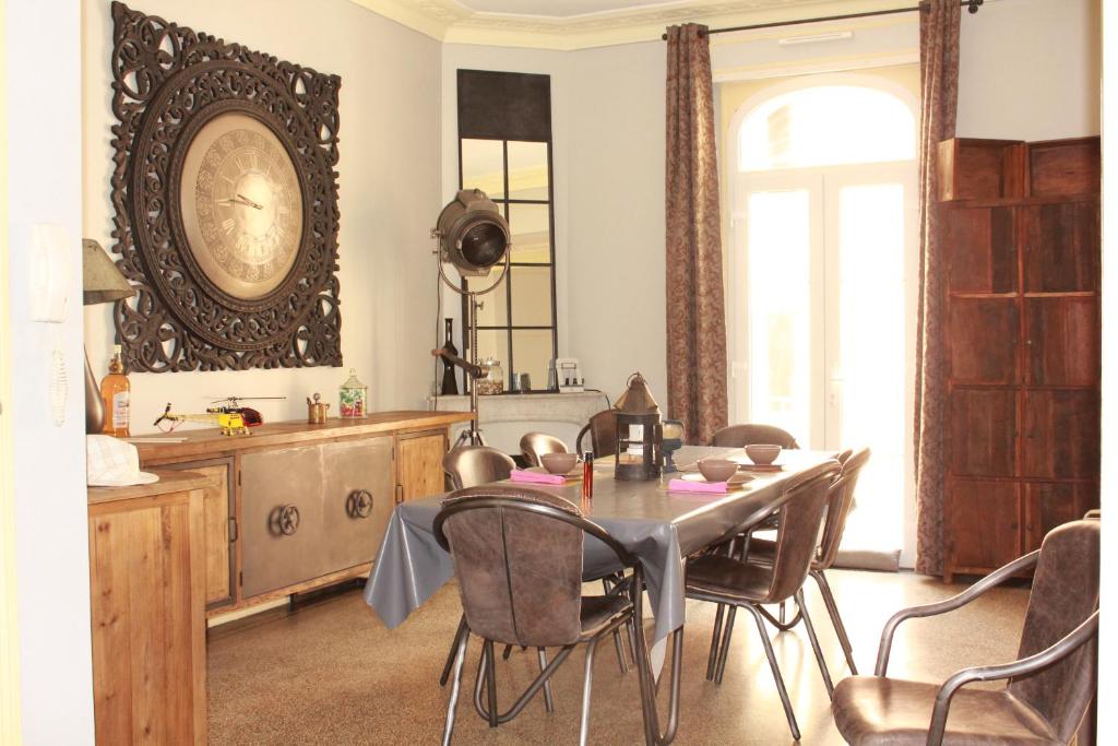 a dining room with a table and a clock on the wall at Appart'hôtel Art Deco in Cannes