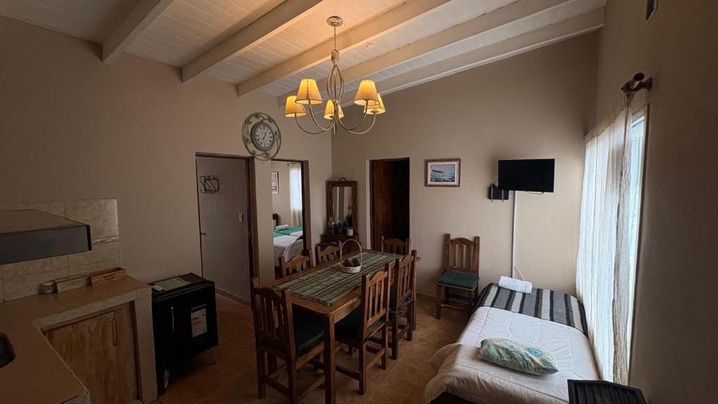 a living room with a dining room table and a bedroom at Hotel Cabañas Aparts Tierra de Glaciares in El Calafate