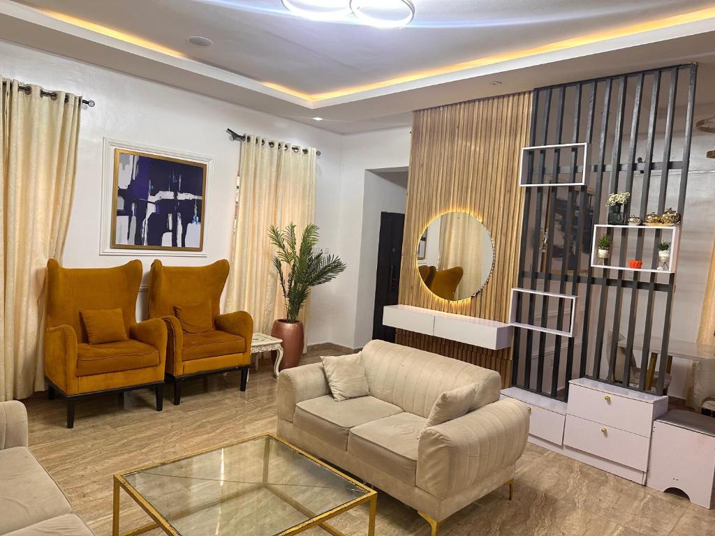 - un salon avec un canapé, des chaises et un miroir dans l'établissement Bliss Haven, à Lekki