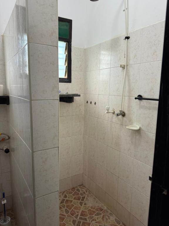 una ducha con puerta de cristal en un baño en Raine house, en Ukunda