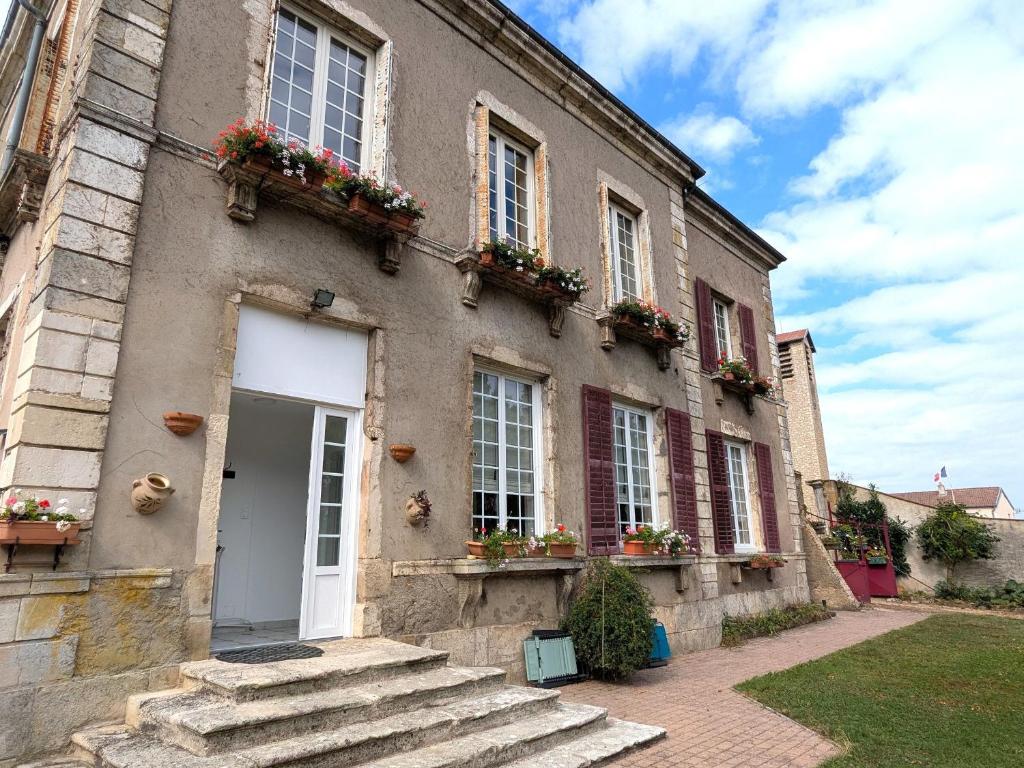 a building with flower boxes on the windows and a door at Gîte confortable pour 4 personnes avec jardin et terrasse près de Nancy - FR-1-584-102 in Villey-le-Sec