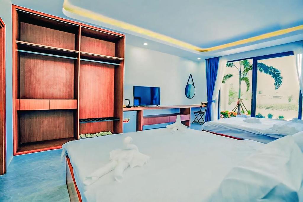 a bedroom with two beds and a large window at The Step Hotel kampot in Kampot