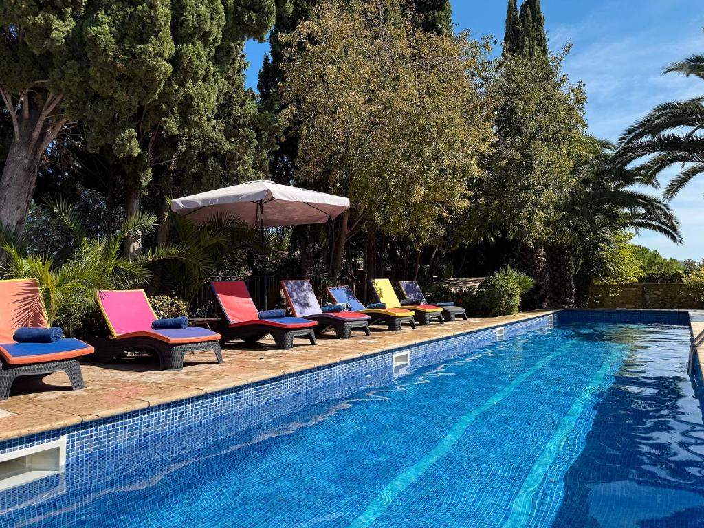 een rij stoelen naast een zwembad bij Masia Notari Casabona in Vilanova i la Geltrú