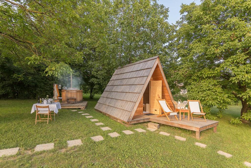 Casa pequeña con mesa, sillas y parrilla en Glamping Bizjak, en Preddvor