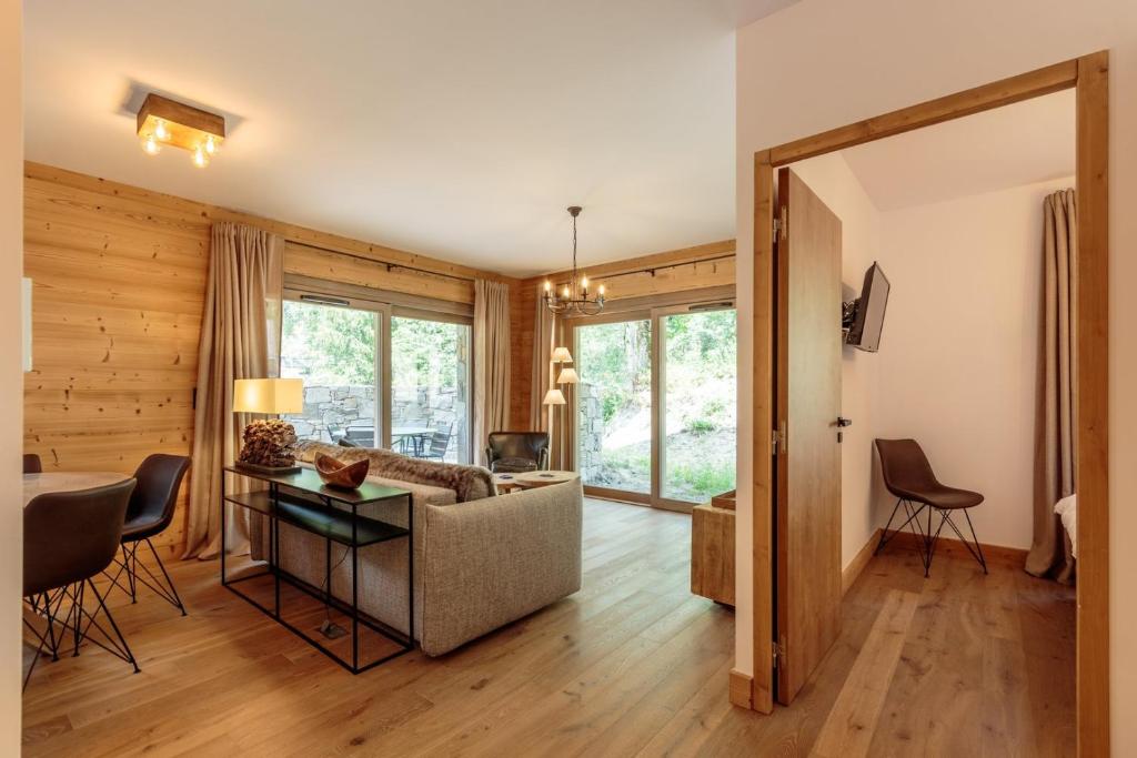 a living room with a couch and a table at Tome, superbe appartement avec terrasse vue montagne in Champagny-en-Vanoise