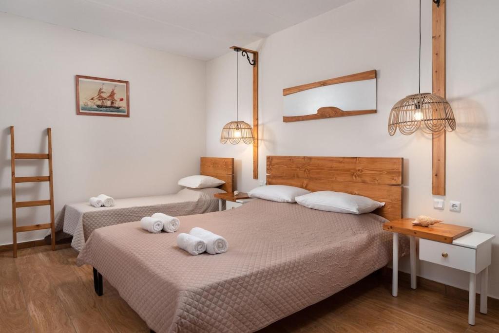 2 Betten in einem Zimmer mit Handtüchern darüber in der Unterkunft The Cottage South Escape with beach front pool in Plimmiri