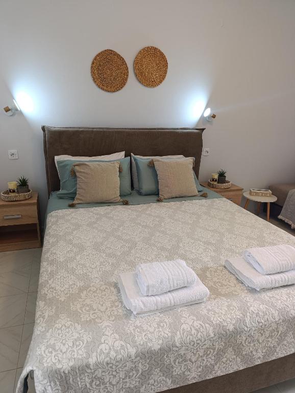a bedroom with a large bed with two towels on it at Agathi Paradise Studios in Haraki