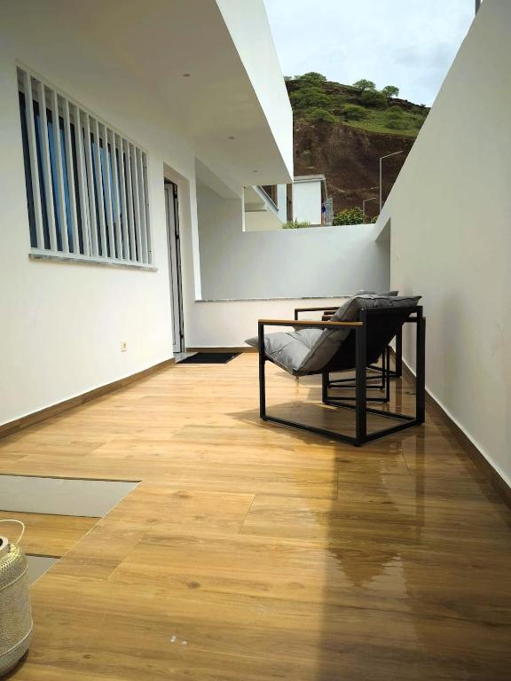 een kamer met een stoel op een houten vloer bij Casa strella in Praia