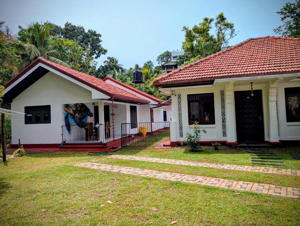 a small white house with a red roof at Canopy villas in Mirissa
