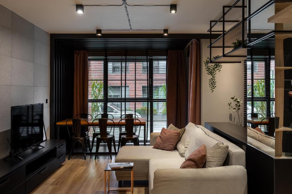 ein Wohnzimmer mit Couch und ein Esszimmer in der Unterkunft Kraków Wawrzyńca Suites by Downtown Apartments in Krakau