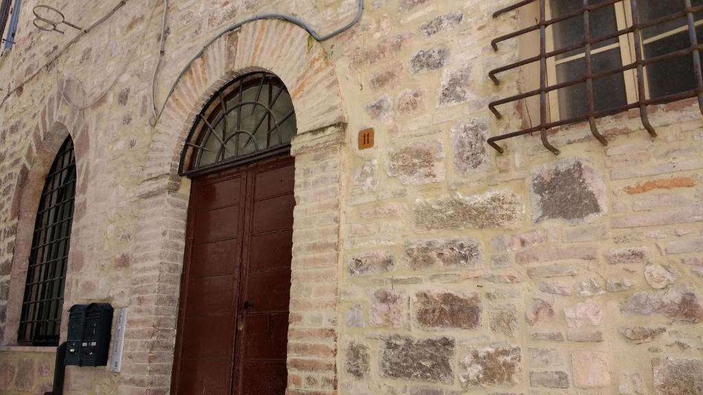 ein Gebäude mit einer braunen Tür und einem Fenster in der Unterkunft Camere Calocci in Assisi