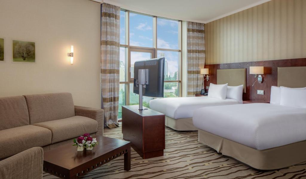 ein Hotelzimmer mit zwei Betten und einer Couch in der Unterkunft DoubleTree by Hilton Bratislava in Bratislava