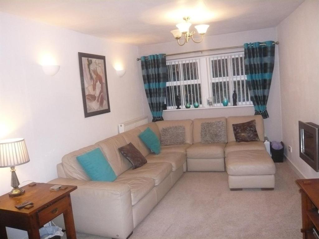 a living room with a white couch with blue pillows at The Georgian Guesthouse in Alnwick